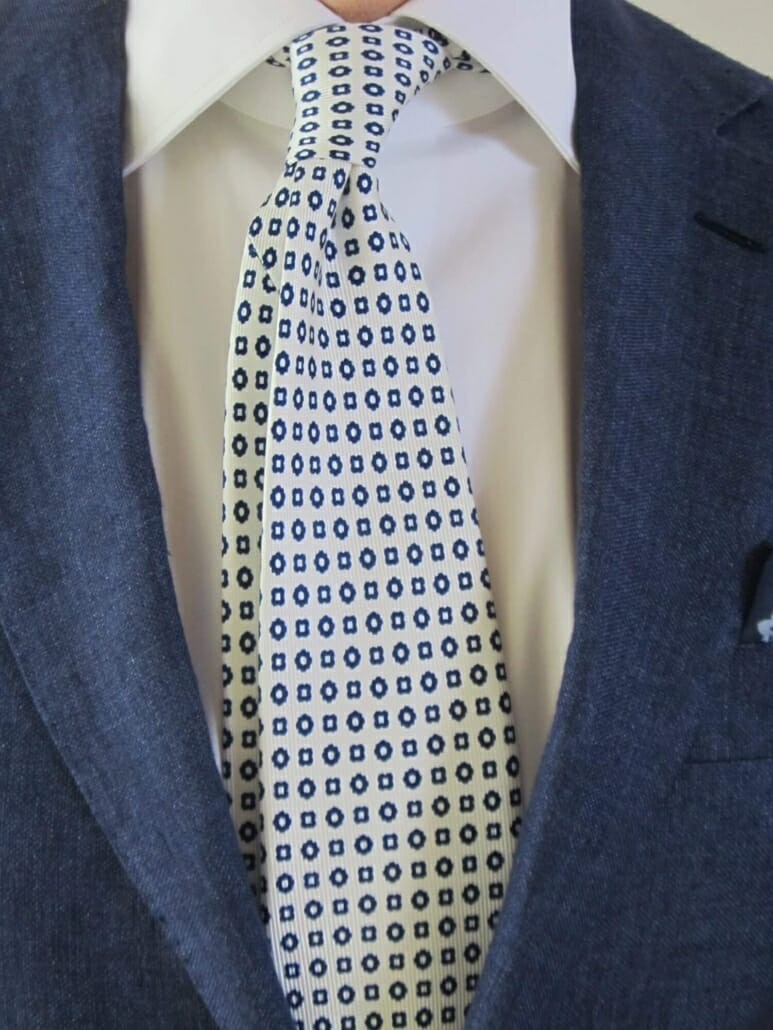 Une cravate en soie blanche à motif géométrique