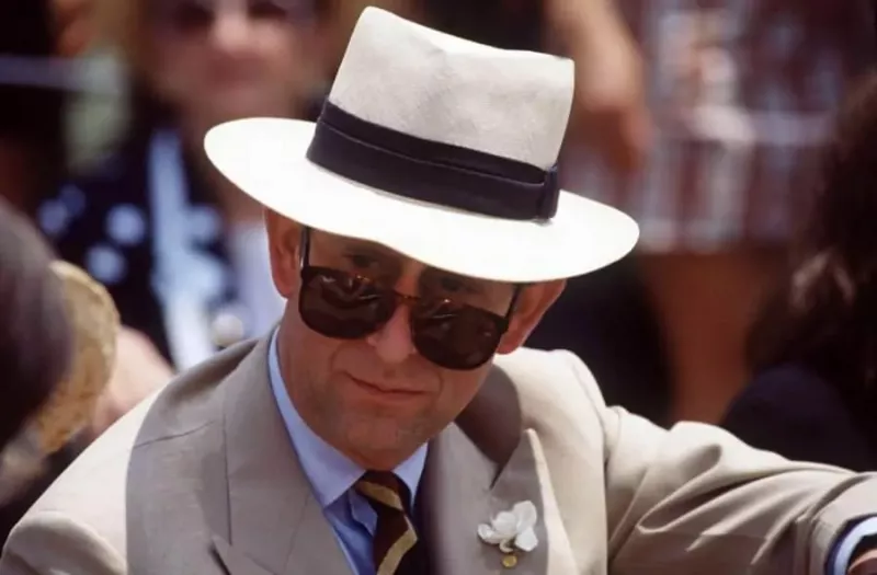 Prince Charles en lunettes de soleil RayBan avec chapeau Panama et boutonnière Gardenia