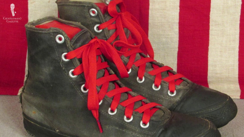 Une paire de chaussures converse noires avec des lacets rouges.