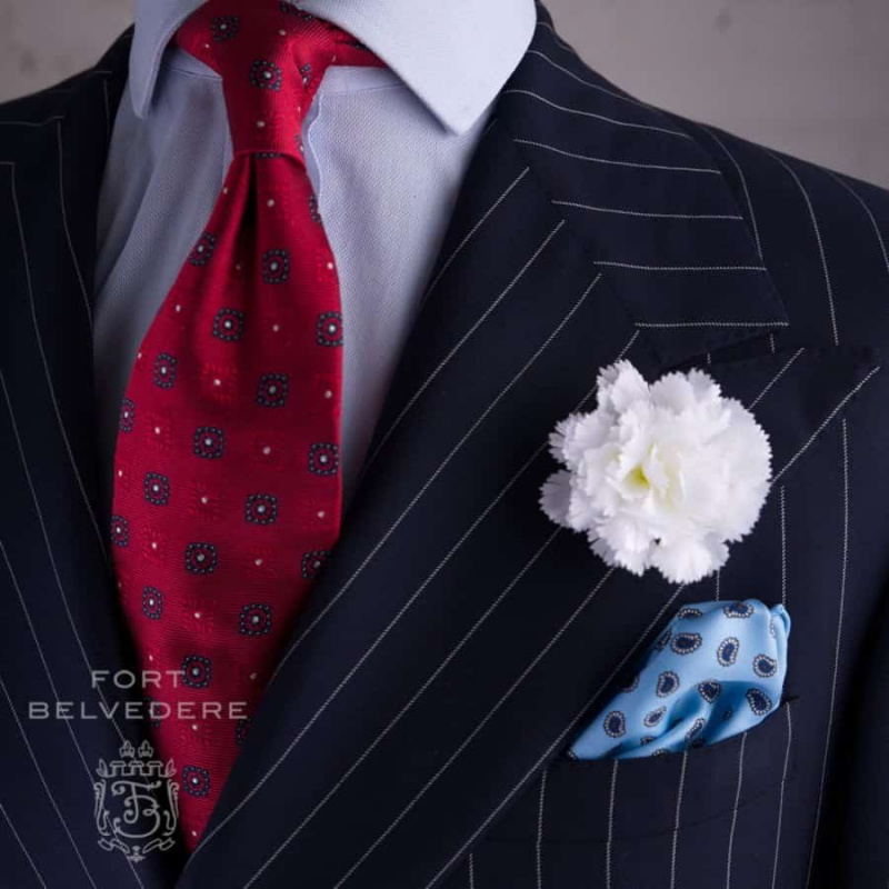 Costume à rayures craie avec grand œillet blanc, pochette de costume en soie bleu clair et cravate en jacquard rouge - le tout par Fort Belvedere