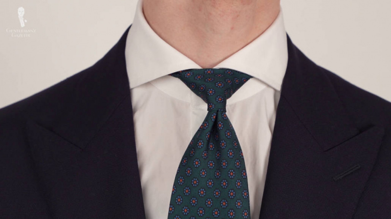 Бела кошуља са раширеном крагном упарена са краватом од мађине свиле у боца зеленом Маклсфилду.
