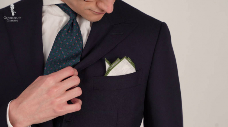 Престон носи морнарско одело са белим платненим квадратним џепом са контрастном зеленом ивицом у преклопу.