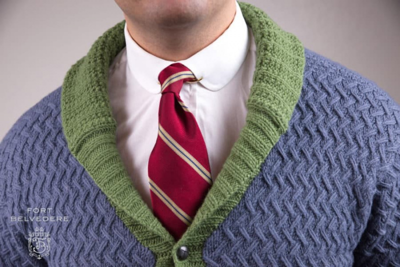 Cardigan en laine tricoté gris et vert associé à une cravate en soie rouge vintage et un clip de col en or