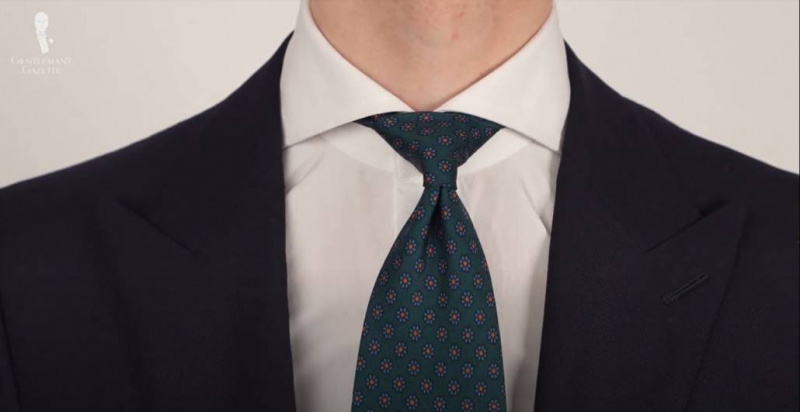 Madder hedvábná kravata v láhvi Zelená Macclesfield Neats Modrý oranžový vzor z Fort Belvedere uvázaná na klasickém roztaženém límci