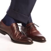 Um par de meias Shadow Stripe com nervuras azul marinho escuro e azul royal usado com sapato borgonha Derby