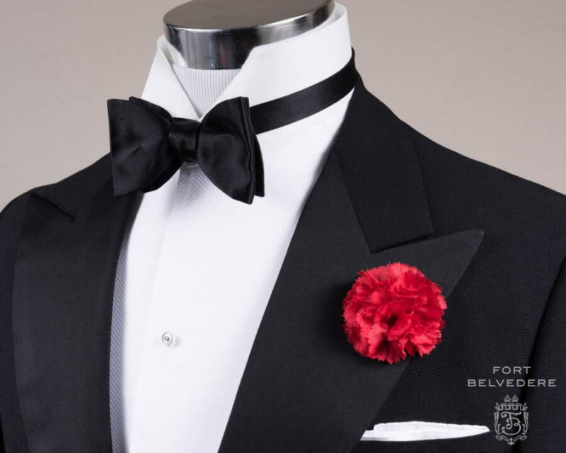 Crna leptir leptir kravata veličine svilenog satena s boutonniereom od crvenog karanfila i klasičnim bijelim irskim platnenim džepićem - Fort Belvedere