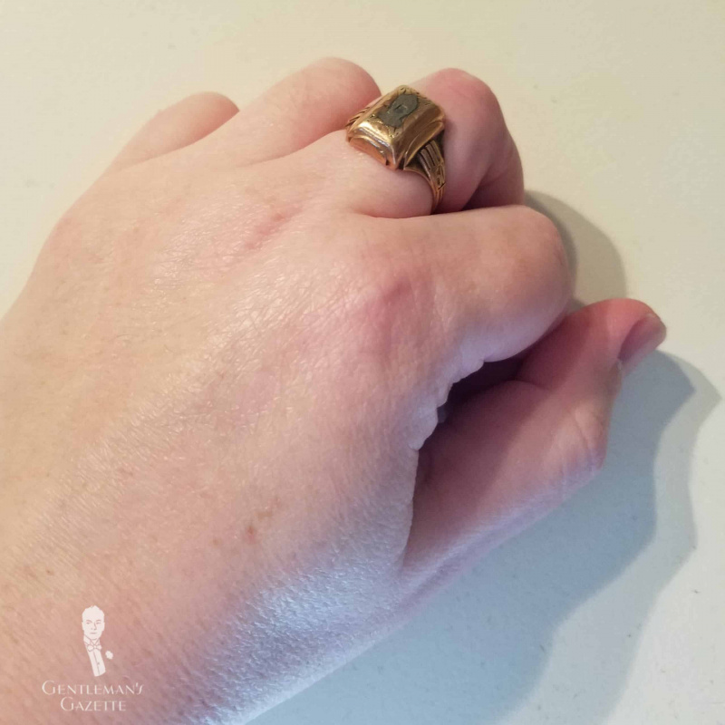 Une main avec un anneau de cuivre sur le majeur