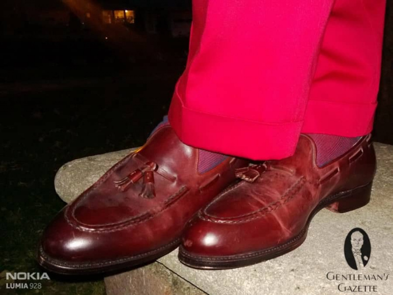 Oxblood Cordovan Tassel Loafers par Meermin, avec des chaussettes rouges à rayures bleues par Fort Belvedere et un pantalon Indochino rouge
