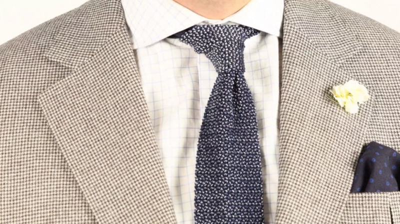 pochette en laine challis bleu marine à pois bleus associée à une veste pied-de-poule une chemise à carreaux et une cravate en tricot bicolore marine et bleu clair