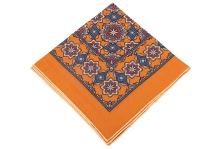 Pochette de costume en laine de soie ocre antique dorée avec médaillons géométriques imprimés en beige, rouge et bleu avec bord contrastant crème