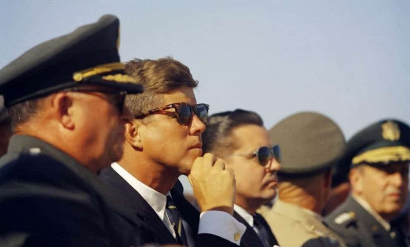 JFK porte des boutons de manchette en or et des lunettes de soleil en écaille de tortue