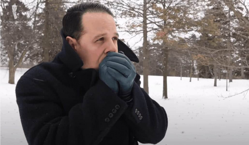 Raphael reste au chaud dans le froid avec un pardessus noir et des gants bleu pétrole de Fort Belvedere