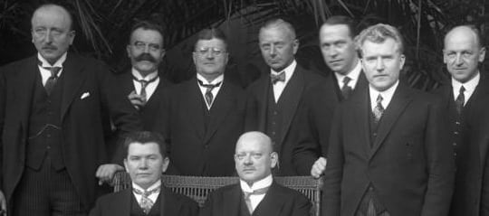 Фотографија 9 мушкараца у типичним Стресемановим ансамблима