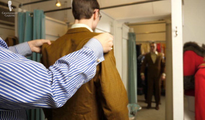 Raphael aide Preston à ajuster une veste devant un miroir