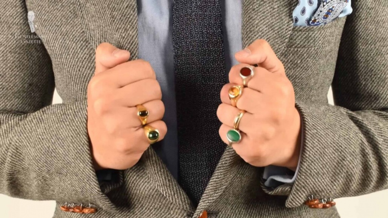 Fotografie páru rukou s mnoha prsteny na prstech