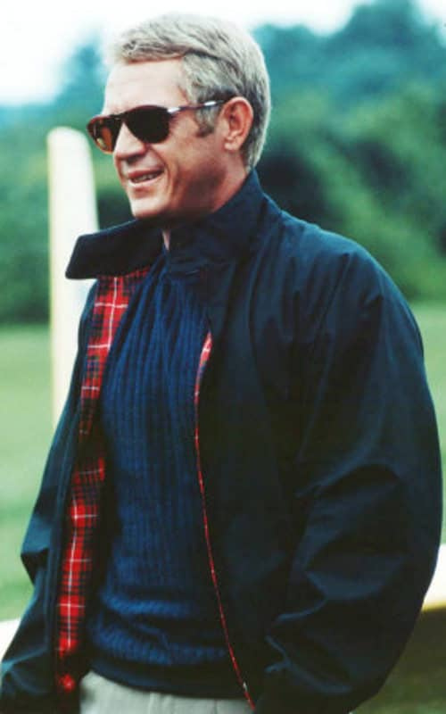Steve McQueen portant des lunettes de soleil Persol et une veste Harrington bleu marine
