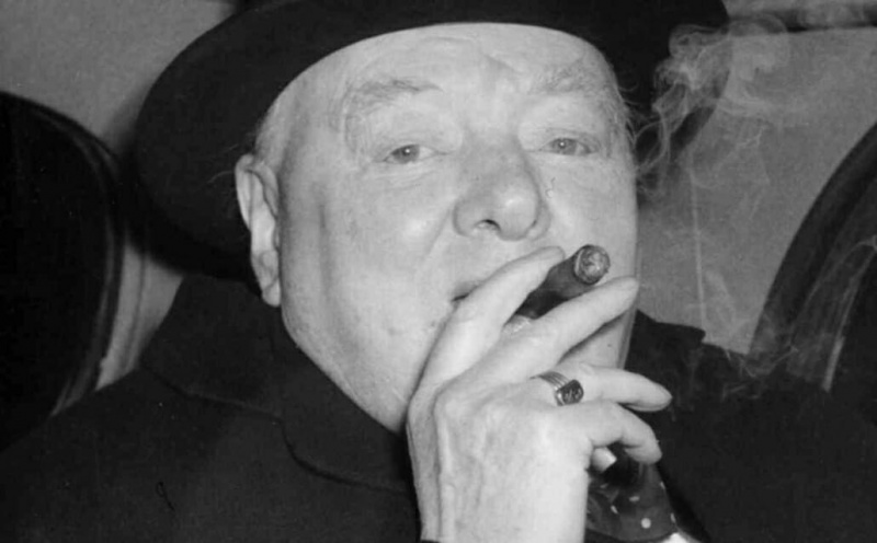 Churchill kouří své typické doutníky s pečetním prstenem na pravé ruce