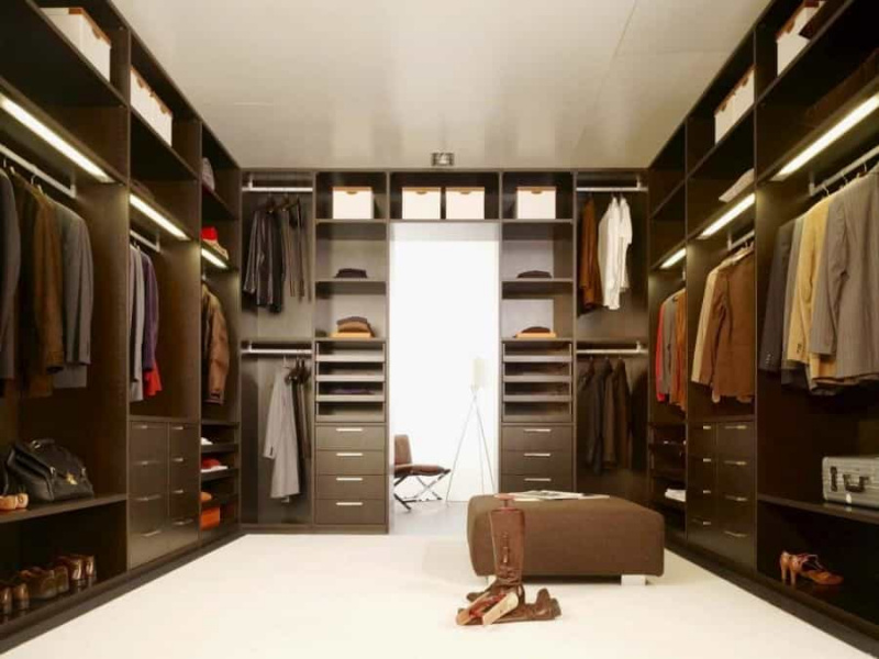 Closet grande com carpete e cabides especiais que permitem que pessoas ainda mais baixas pendurem suas roupas no rack superior