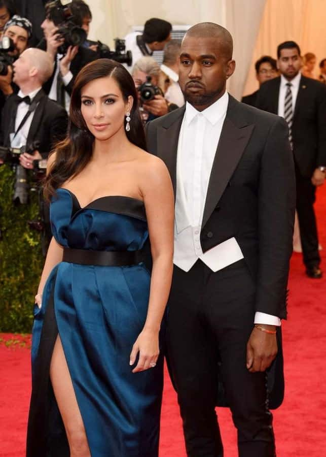 Kanye West ve špatně padnoucím fraku bez motýlka nebo cvočků, ale kalhoty, které jsou tak těsné, že se mačkají