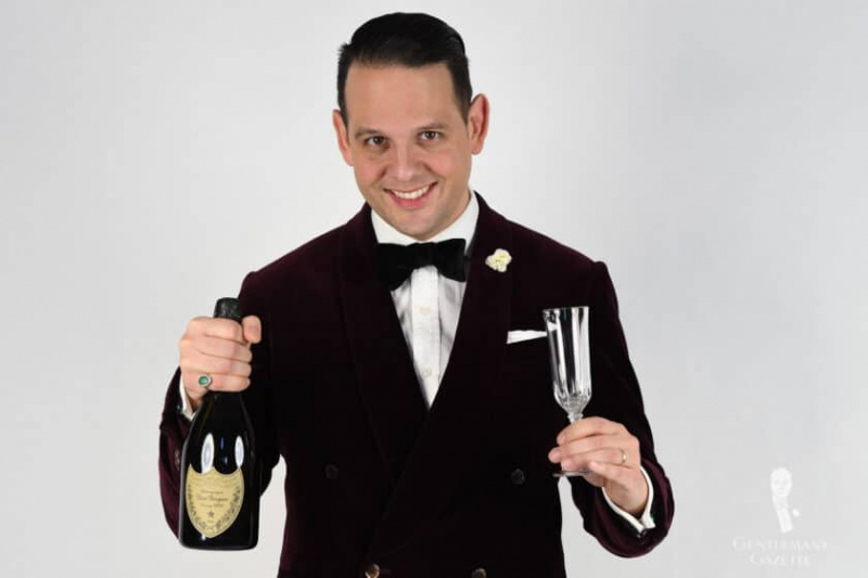 Raphael Schneider tient une bouteille et une coupe de champagne