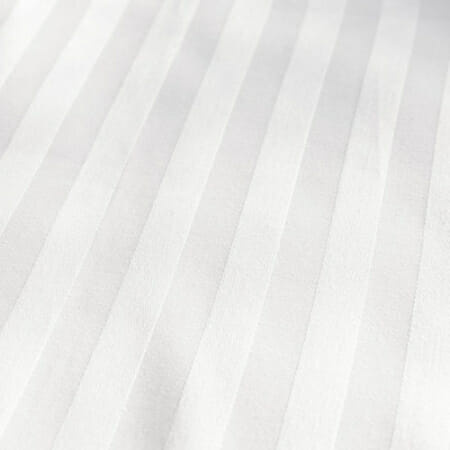 Сатенске пруге у белој боји, представљене под углом да покажу како светлост утиче на дизајн.