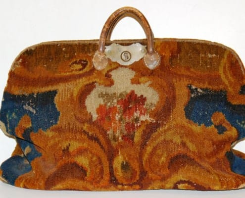 Un simple bagage fabriqué à partir de tapis et moquettes orientaux, avec une charnière en fer en haut comme seul cadre structurel du sac.