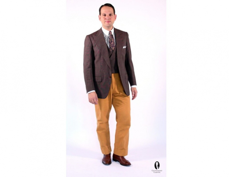 A calça pode ser o ponto central do seu look; aqui, Sven Raphael Schneider combina um paletó marrom com calças amarelas ousadas com punho alto.