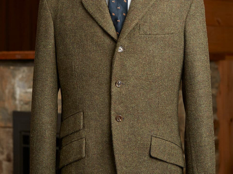 Bolsos horizontais em comparação com os bolsos angulares em uma jaqueta de tweed de três botões.