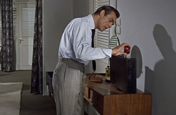 Sean Connery como James Bond, vestindo calças com bolsos verticais.