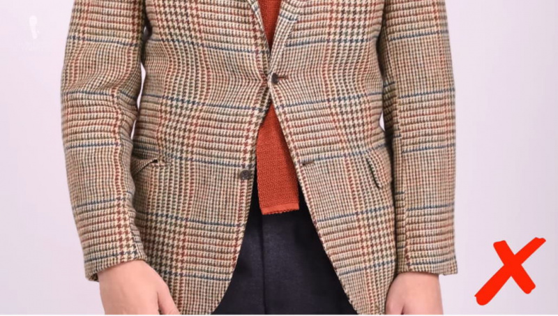 Definitivamente um faux pas da moda - sua gravata nunca deve aparecer debaixo de sua jaqueta