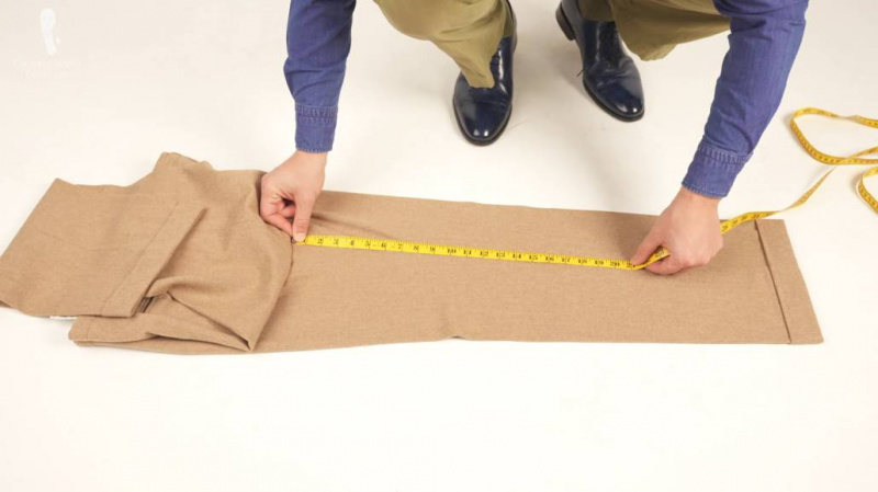 Raphael medindo a costura de sua calça enquanto estava deitado no chão.