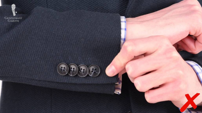 Há quatro botões de beijo nas mangas com apenas uma leve sugestão de casas de botão.