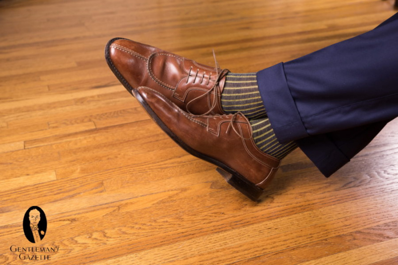Hnědé norské boty s námořnickými a žlutými ponožkami v kombinaci s námořnickými kalhotami