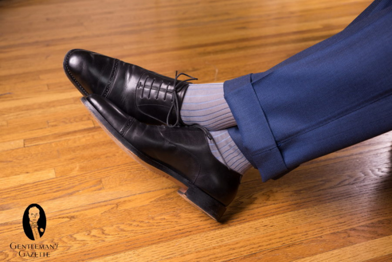 Двобојне чарапе светлије боје пружају занимљив контраст, али плава повезује панталоне и чарапе