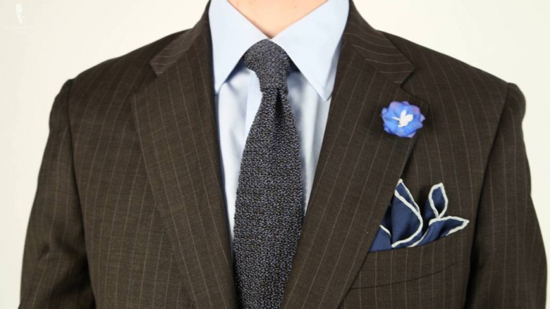 Tmavší vzorovaný oblek s odvážnějšími doplňky pro méně formální kancelářský vzhled. (pletená kravata, boutonniere a kapesníček z Fort Belvedere)