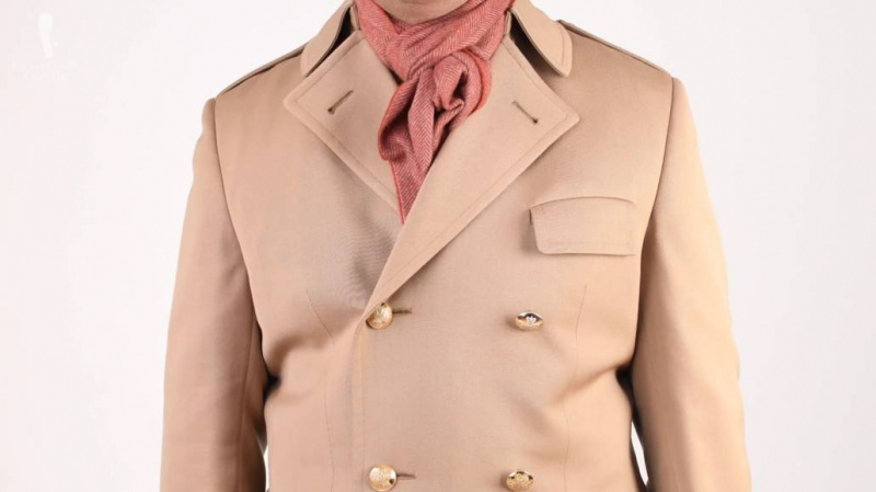 Raphael má na sobě kašmírový šátek ve tvaru rybí kosti v šedooranžovém a hnědém kabátě.