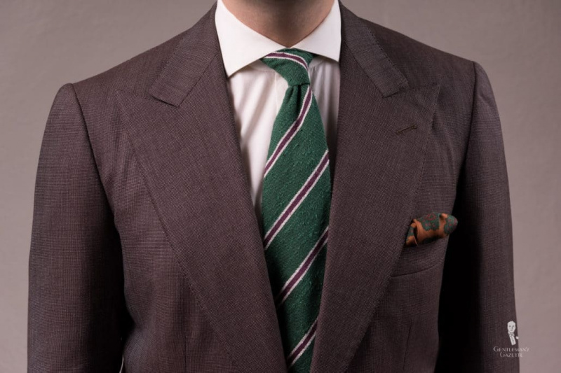 Cravate en soie shantung rayée vert, violet et crème et pochette de costume en soie garance bronze foncé avec motif diamant et cachemire de Fort Belvedere.