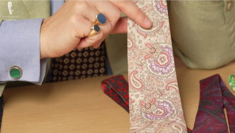 Raphael montre une cravate cachemire inhabituelle avec une base blanc cassé