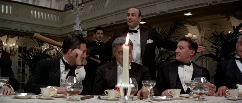 Al Capone em um conjunto de gravata preta segurando um taco de beisebol