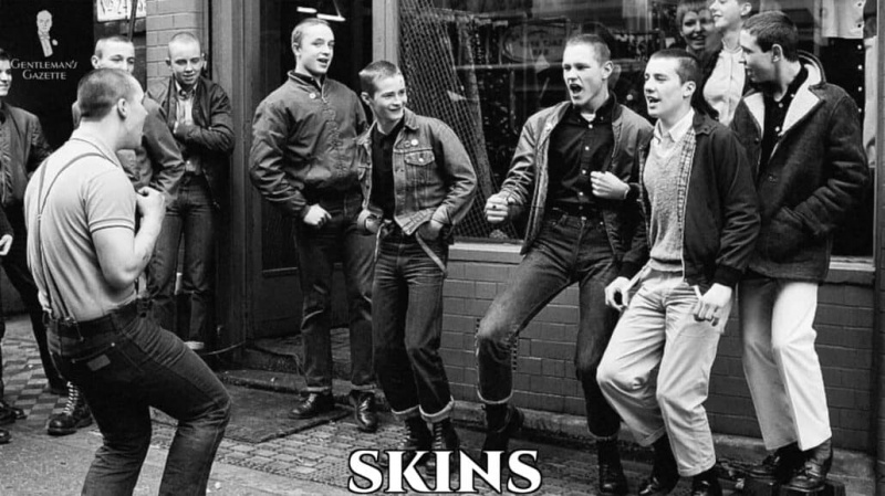Un groupe de jeunes hommes au crâne rasé portant des tenues inspirées des skins.