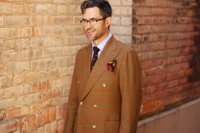 Pedro Mendes avec veste DB à carreaux, cravate en maille bordeaux à pois et pochette flamboyante