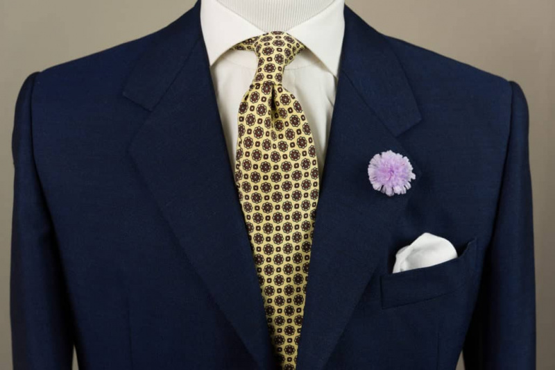 У овој класичној тамноплавој и жутој комбинацији, љубичаста Фиелд Сцабиоус Боутонниере додаје дашак боје пригушеној кравати, кошуљи и сакоу.