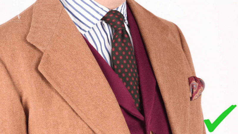 Raphael draagt ​​een dongaals tweedpak in bruin, gestreept overhemd en bordeauxrood vest