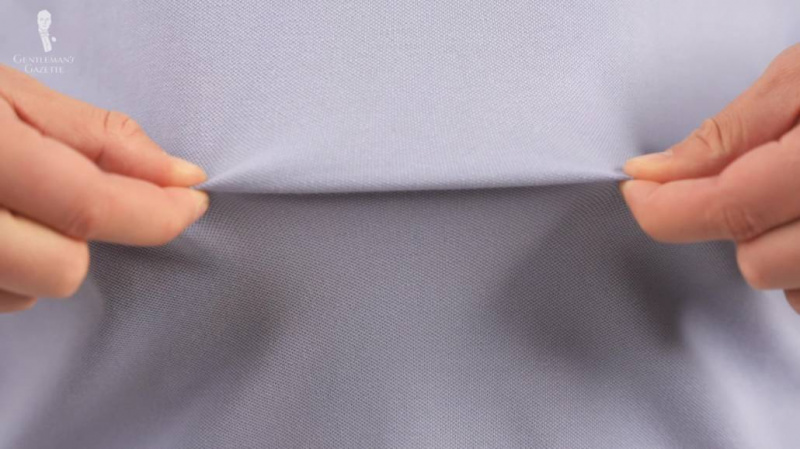 Raphael étire sa chemise Lacoste pour montrer à quel point un tissu piqué est souple.