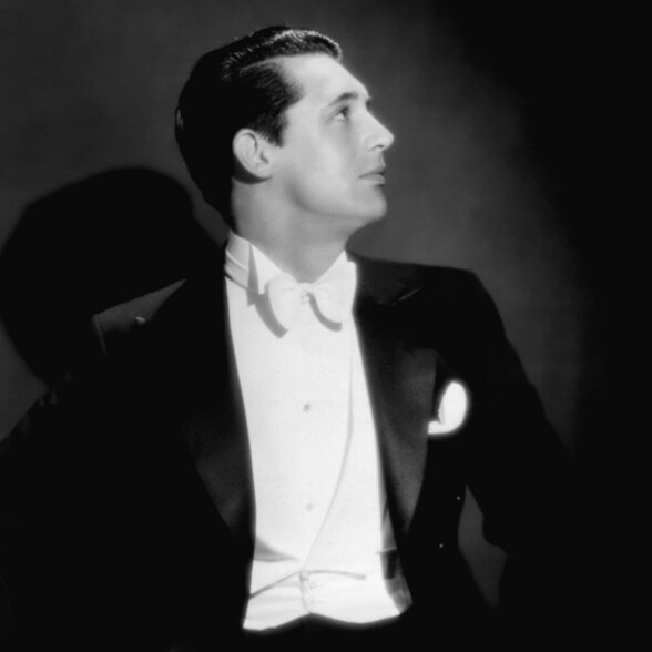 Jonge Cary Grant in witte stropdas, niet de kleine vlinderdasknoop en onopvallende ronde giletuiteinden