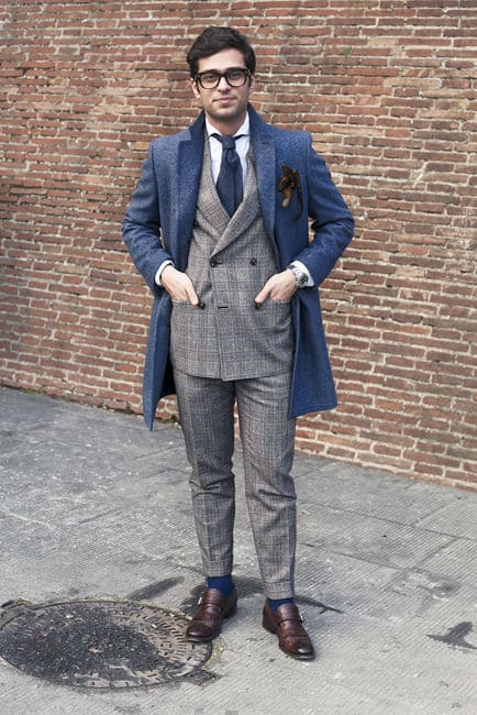 Davide Baroncini em terno marrom escuro com sobretudo azul e sapatos