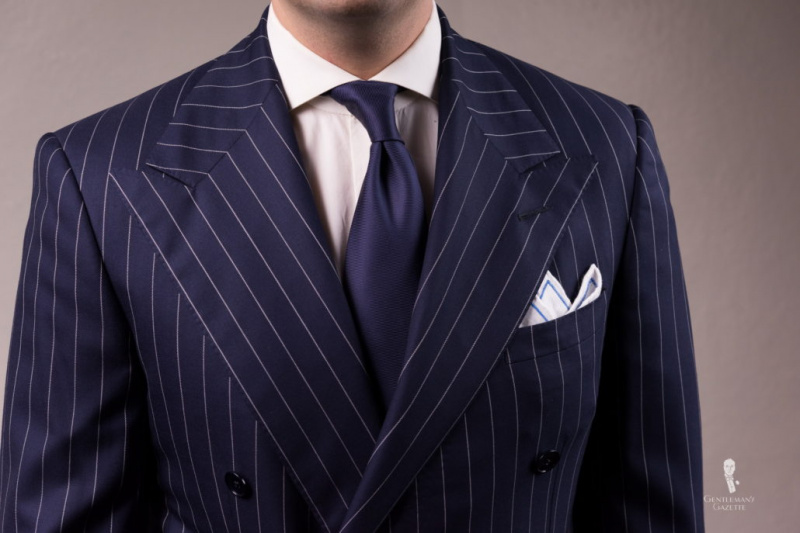 Costume à rayures craie avec cravate bleu marine et pochette de costume contrastée brodée en lin irlandais blanc