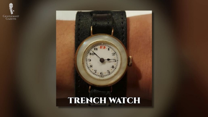 Une vieille montre trench avec un bracelet en cuir noir.