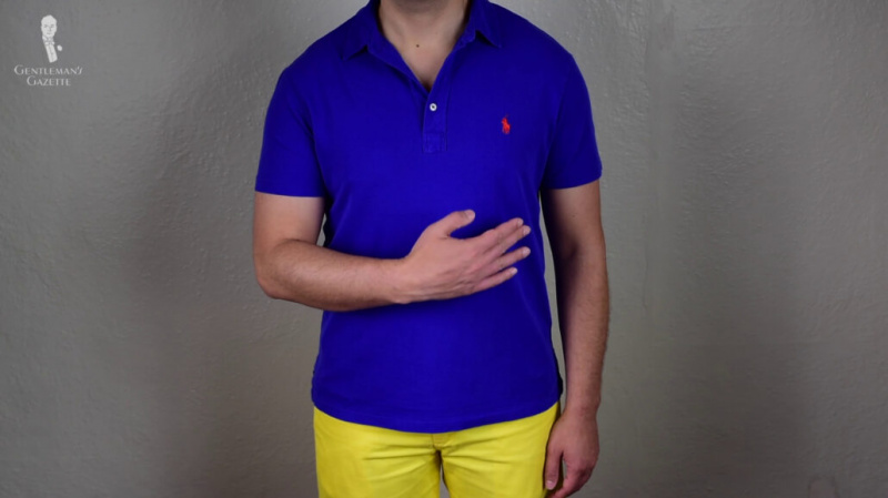 Raphael vestindo uma camisa polo azul e um par de camisas amarelas