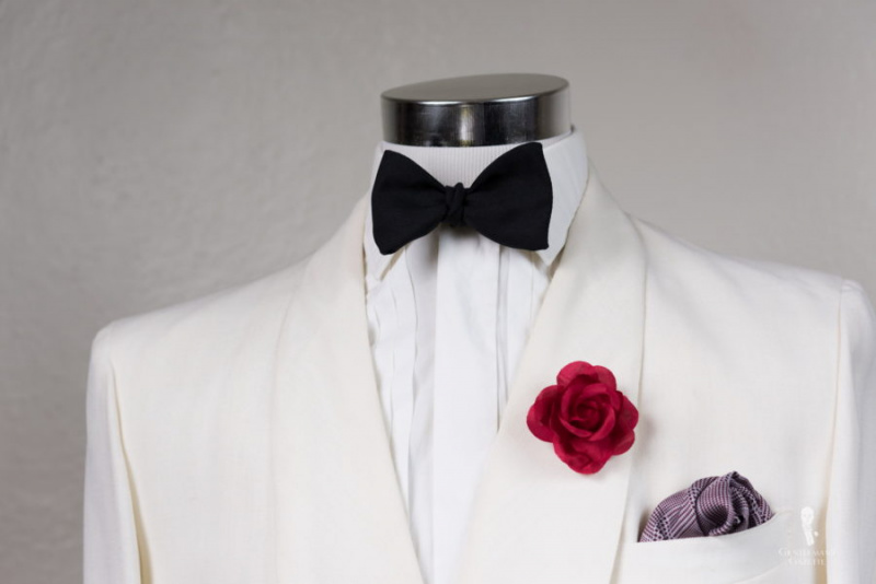 Jaqueta off-white com lapela de rosa vermelha Fort Belvedere e gravata borboleta preta em seda Barathea e lenço de bolso de seda xadrez glen Borgonha